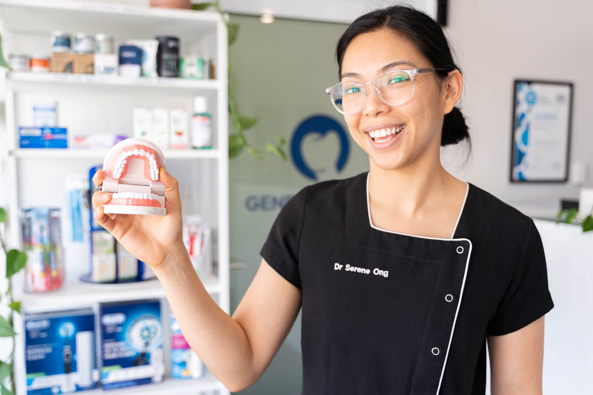 Dr. Serene Ong holding a pair of dentures in our Canning Vale clinic