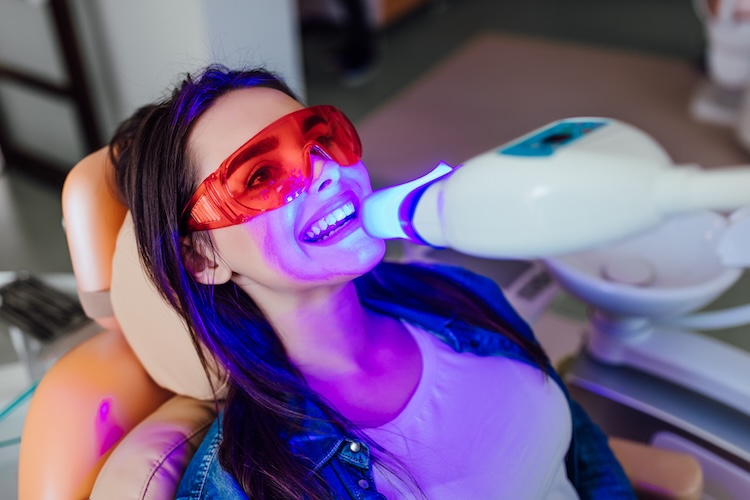 Woman receiving teeth whitening from a dentist