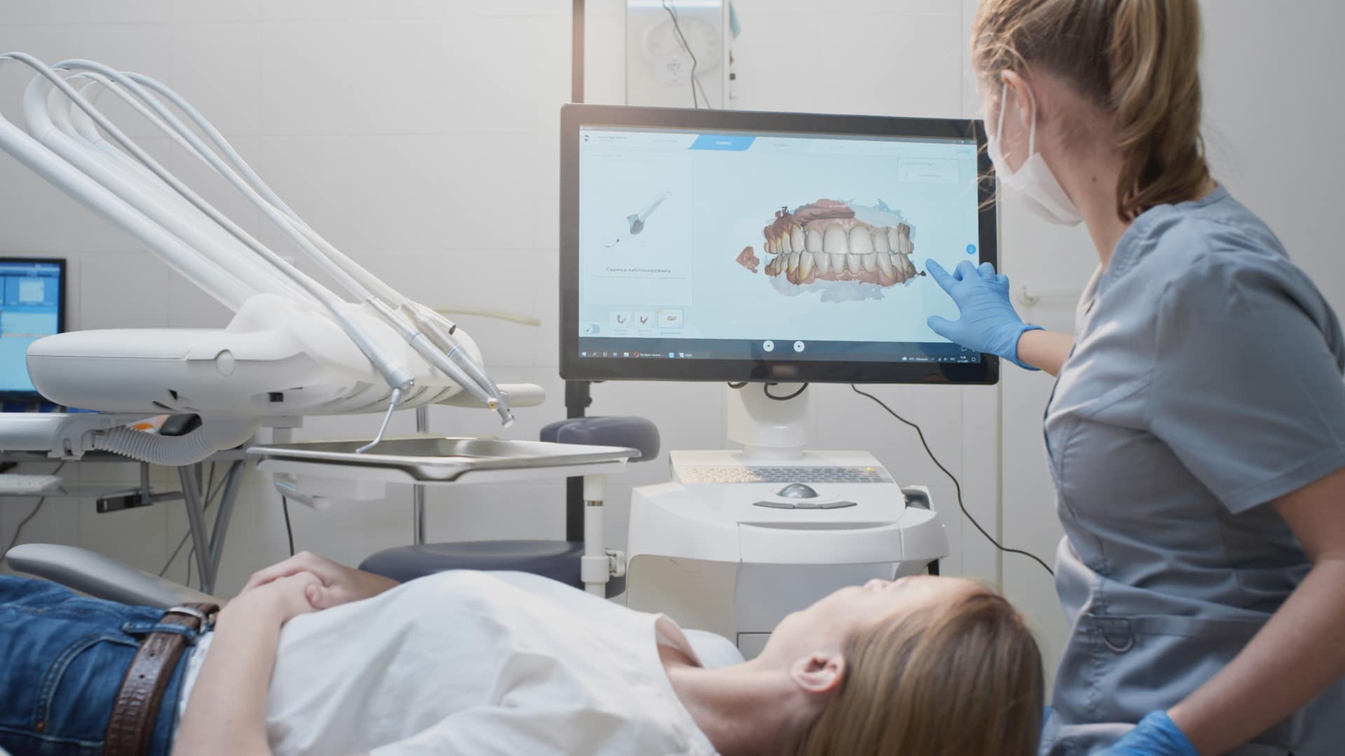 Dentist with patient showing screen answering what are digital dental impressions