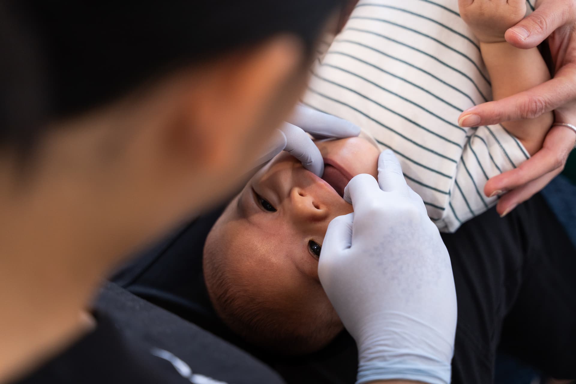 Dentist checking child for symptoms of dry mouth