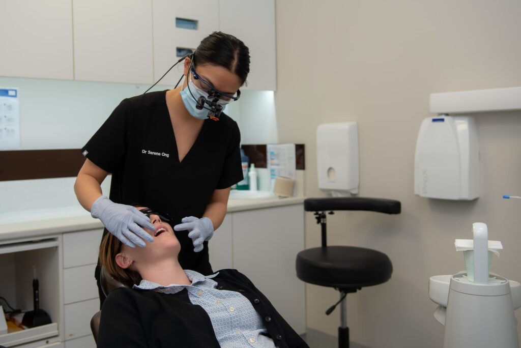 Dentist looking into patients mouth explaining what is gingivitis