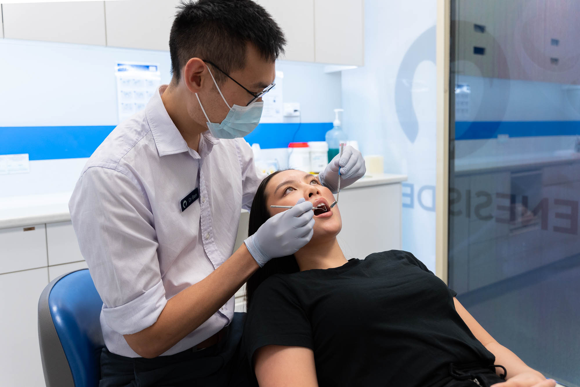 Dentist assessing patients mouth explaining what is a tooth extraction